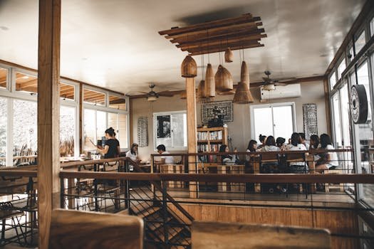 A modern café interior featuring a group dining, wooden decor, and natural lighting.