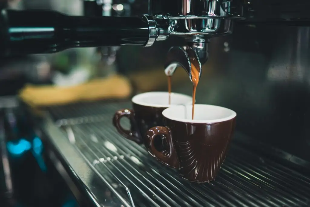 Close-up of a professional espresso machine brewing coffee into cups.
